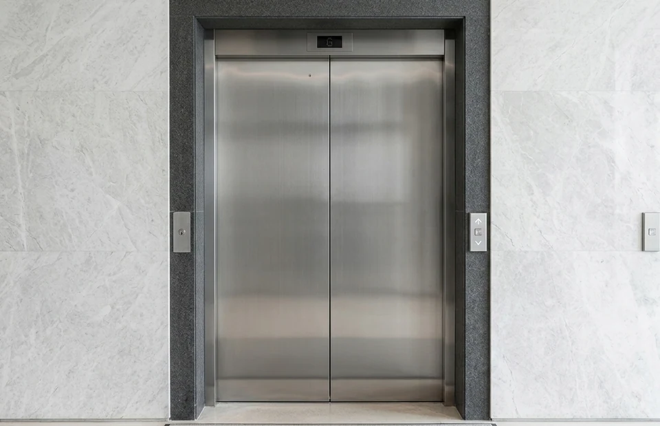 Portas de elevador em aço inox com portal de pedra cinza